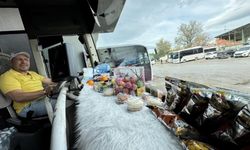 Şoför, minibüste yolculara meyve ve şekerleme ikram ediyor.